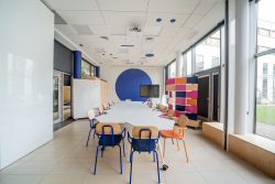 Przestronny biały stół, doskonały do wspólnej pracy i kreatywnych spotkań.