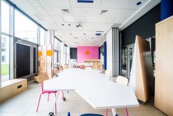 Przestronny biały stół z krzesłami, doskonały do spotkań i współpracy.