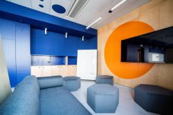 Nowoczesne biuro w niebiesko-pomarańczowych kolorach z telewizorem, idealne do pracy.