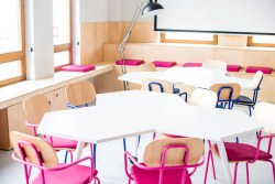 Biały stół otoczony krzesłami, tworzący przytulne miejsce do spotkań.