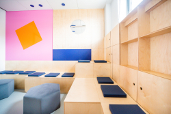 Przestrzeń kreatywnej współpracy z różnokolorowymi ścianami i licznymi miejscami do siedzenia.