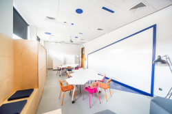 Przestrzeń do kreatywnej współpracy z eleganckim stołem, krzesłami i dużą tablicą, idealna do spotkań i burzy mózgów.