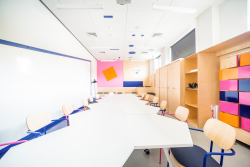 Przestrzeń z stołem i krzesłami, sprzyjająca kreatywnej współpracy i interakcji.