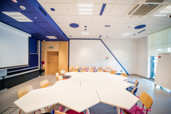 Przestronny pokój z białym stołem i krzesłami, sprzyjający kreatywności i pracy.