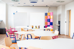 Biały stół otoczony krzesłami, idealny do wspólnej pracy i spotkań w przyjaznej atmosferze.