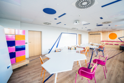 Wnętrze z różnokolorowymi krzesłami i stołami, sprzyjające współpracy i twórczym pomysłom.